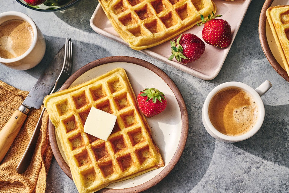 Waffles arranged on plates with fresh fruit