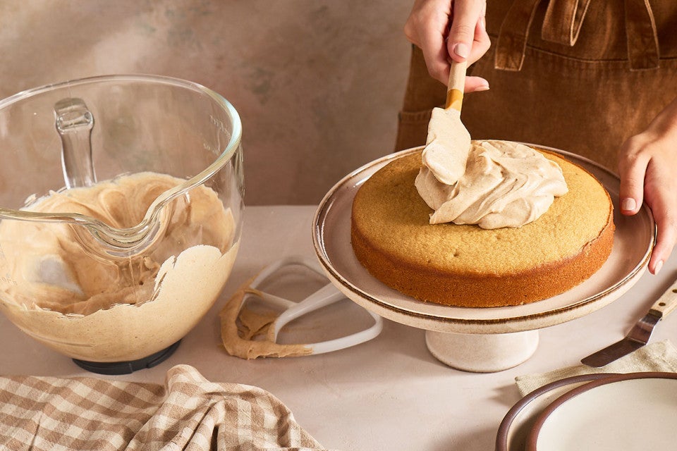 Spreading Brown Butter Cream Cheese Frosting on a caked