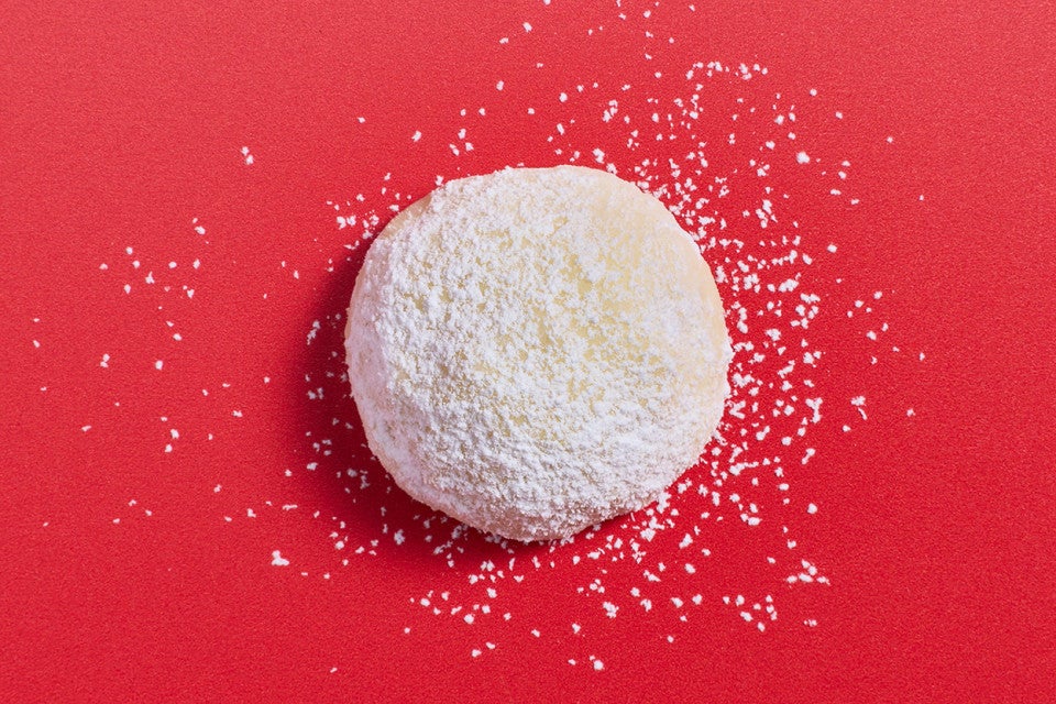 A Lemon Snowball Cookie on a red background