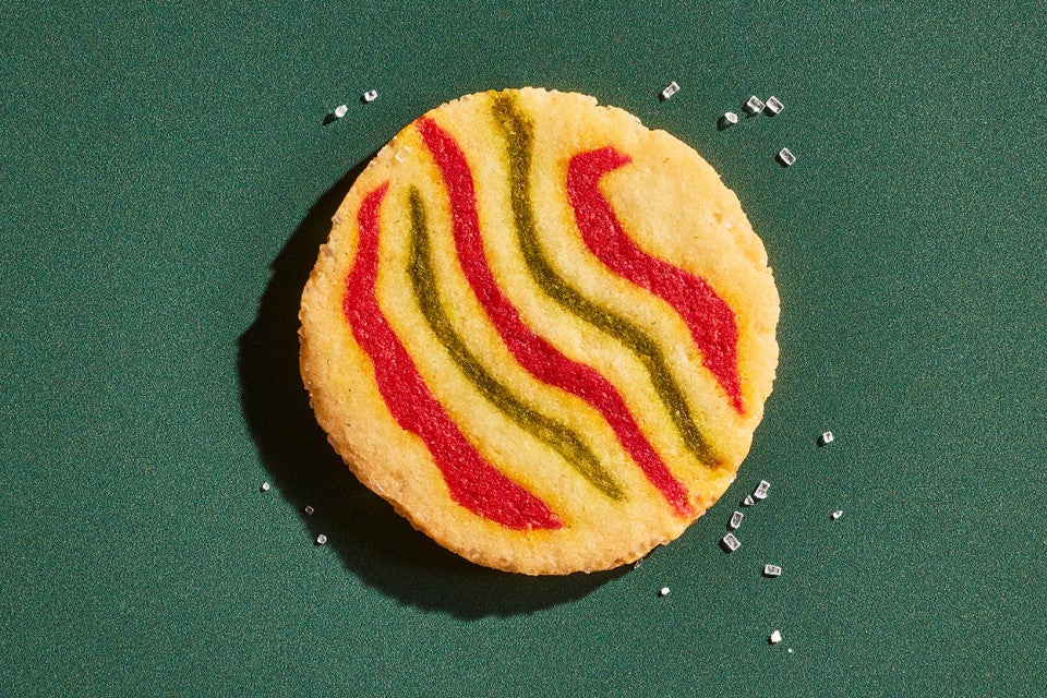 A Ribboned Peppermint Shortbread Cookie on a green background