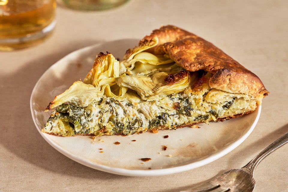 A slice of Spinach Artichoke Galette on a white plate