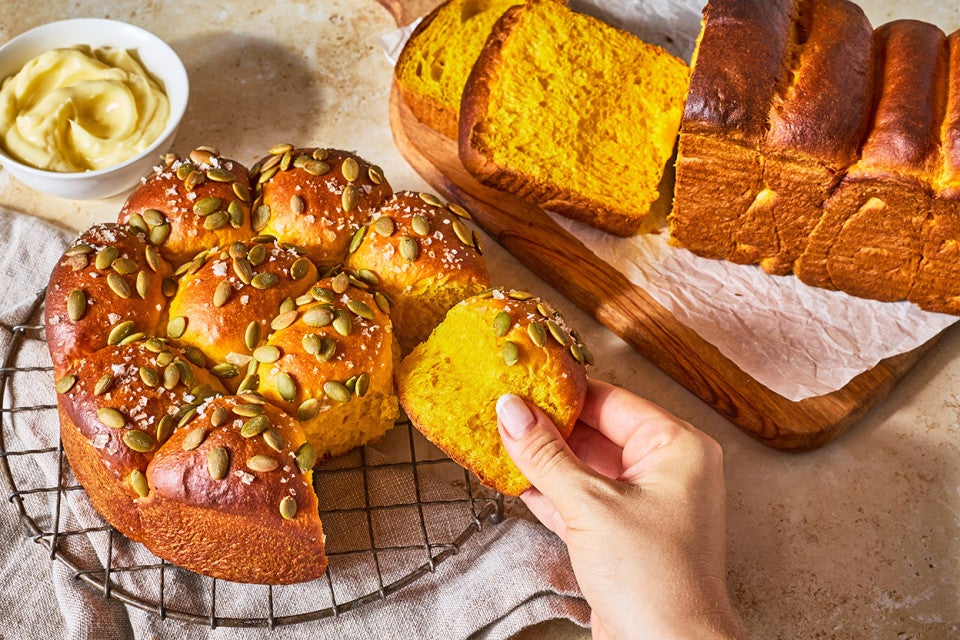 Taking a Pumpkin Milk Bread roll from the baked roll loaf