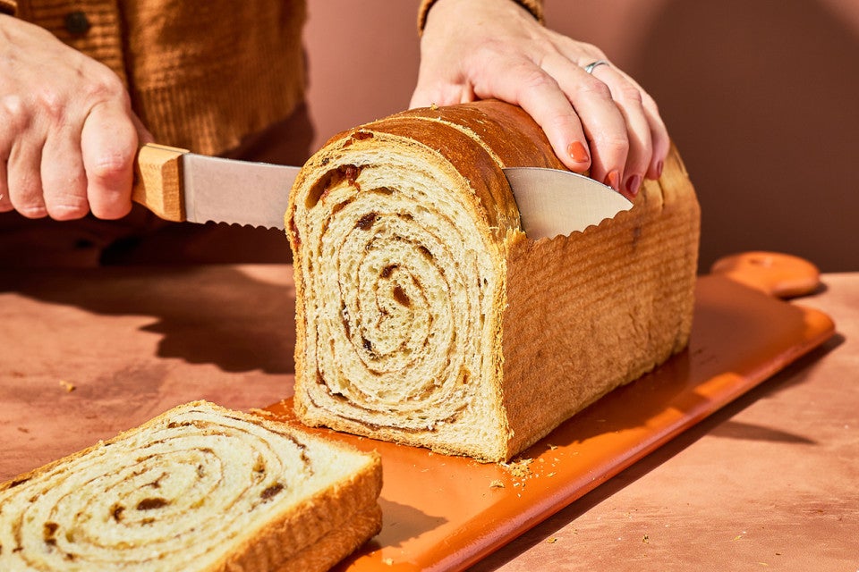 Slicing a loaf of Sourdough Cinnamon Swirl Bread