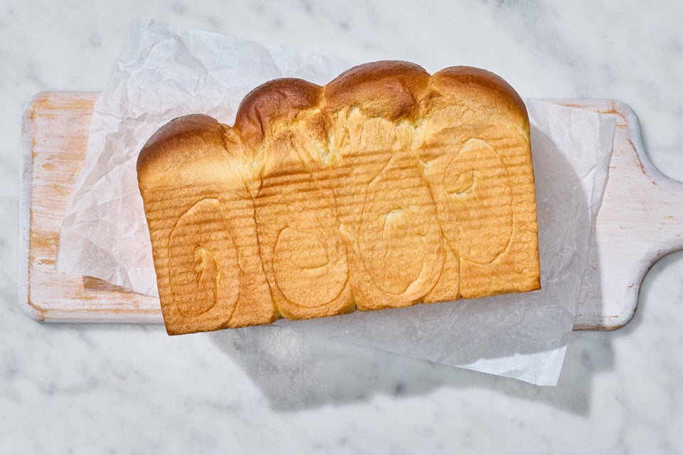 Sourdough Milk Bread fresh out of the pan shown on a marble counter
