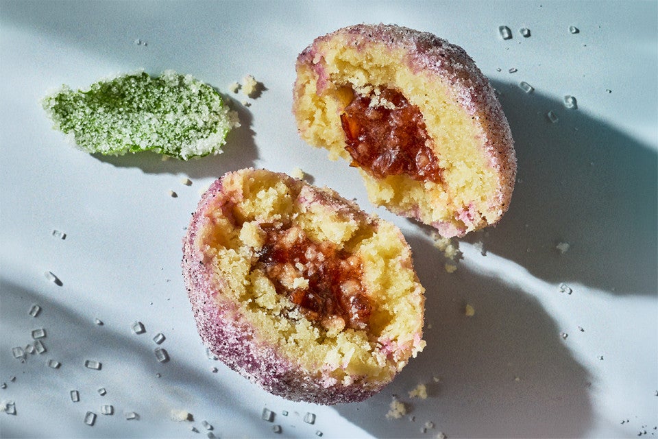 A halved Sugar Plum Cookie on a counter showing the filling and tender cookie