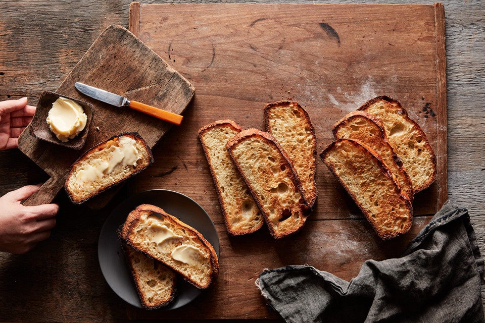 Absolutely No-Knead Crusty White Bread sliced and arranged on a rustic cutting board