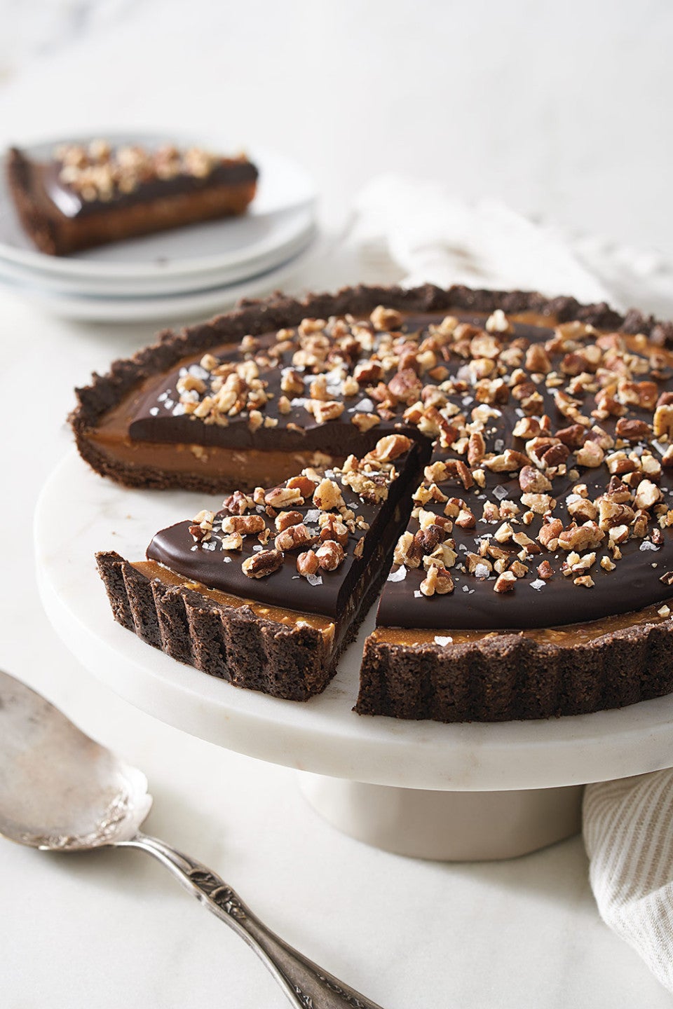 Salted Caramel Chocolate Tart on a marble pedestal