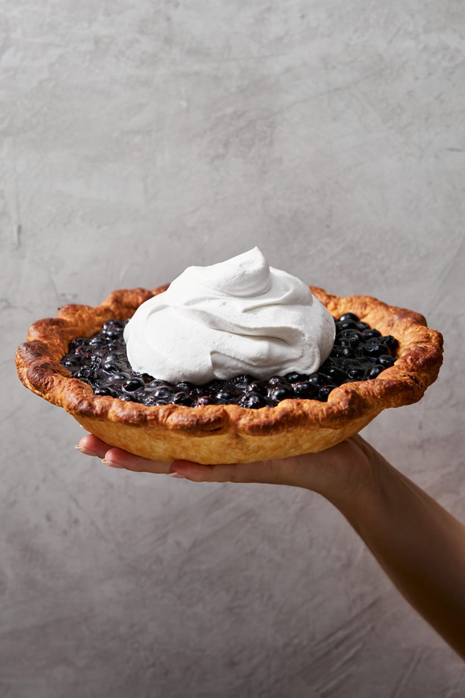 Holding fresh blueberry pie