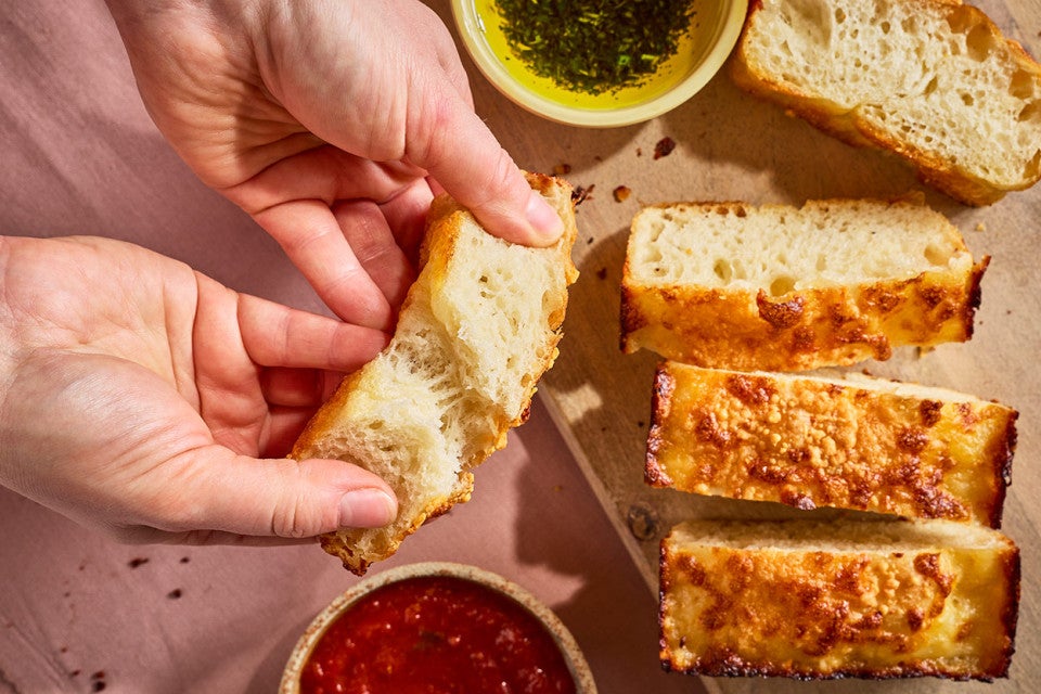 Breaking apart a slice of Small-Batch Cheesy Focaccia