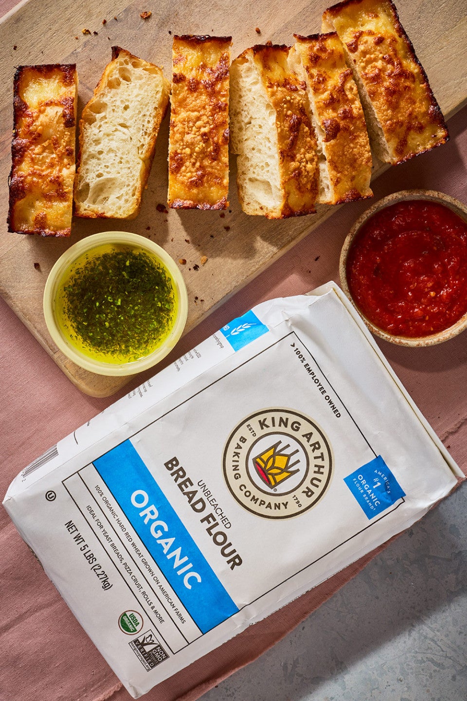 Small-Batch Cheesy Focaccia sliced on a cutting board and a bag of King Arthur Baking Organic Bread Flour