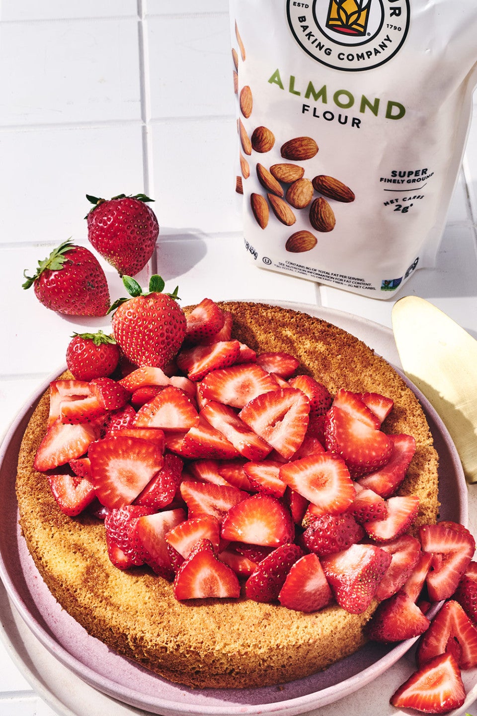 Strawberry Almond Flour Cake seen from above with a bag of King Arthur Baking Almond Flour