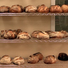 Loaves of artisan bread stacked on a cooling rack