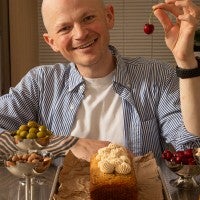 Jordan Smith in front of a loaf cake, holding up a cherry