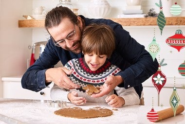 Family baking in the kitchen, rolling out gingerbread cookies