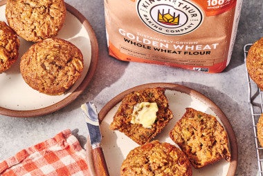 Morning Glory Muffins on plates and a bag of King Arthur Baking Golden Wheat flour.