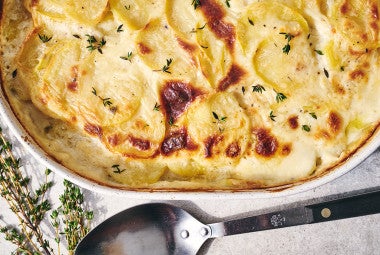 Scalloped Potatoes fresh out of the oven in a stoneware pan seen from above