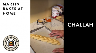 Unbaked braided challah on half sheet pan