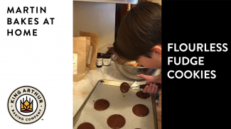 Arlo scooping flourless fudge cookie batter onto baking sheet